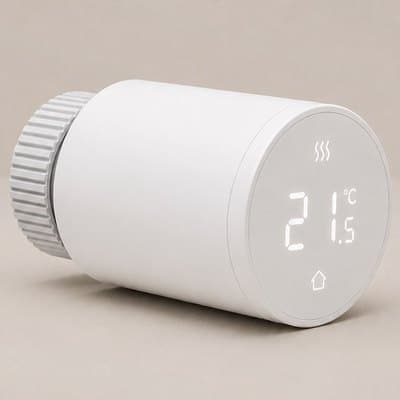 A smart radiator thermostat, a white cylinder with a ridged collar, its face reading twenty one and a half degrees.