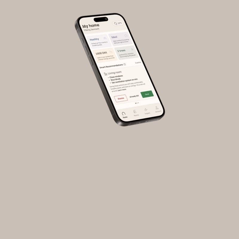 The SmartClimate app on a phone, showing a home in Viborg with its air quality, comfort and the money saved so far.